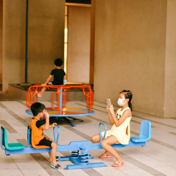 2 boys sitting on blue and red basketball court
