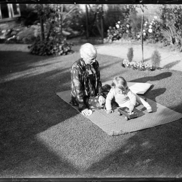 2 children sitting on the ground in grayscale photography