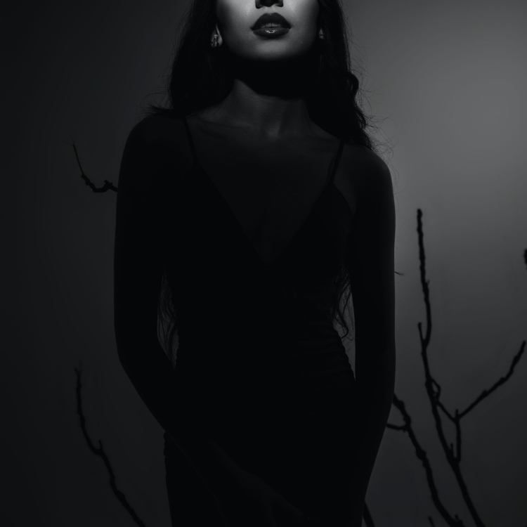 A black and white photo of a woman in a black dress