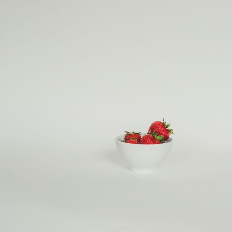 A bowl of strawberries on a white background