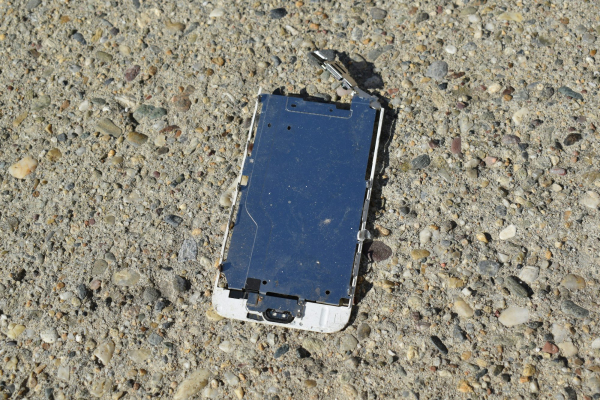 A broken cell phone laying on the ground