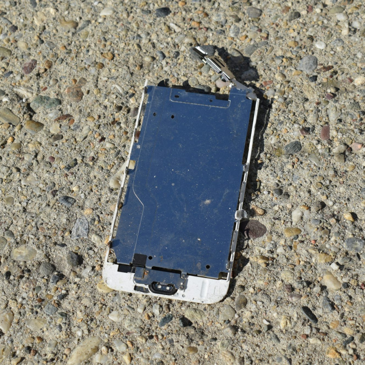 A broken cell phone laying on the ground