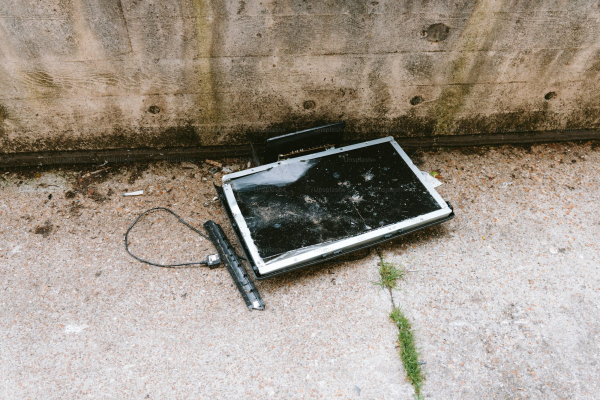 A broken tv screen lies abandoned on the ground