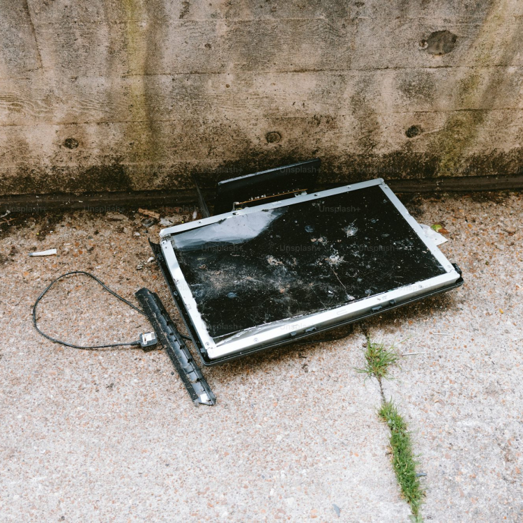 A broken tv screen lies abandoned on the ground