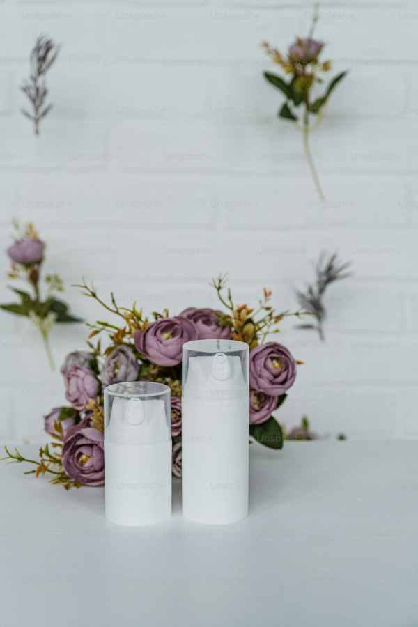 A couple of white candles sitting on top of a table