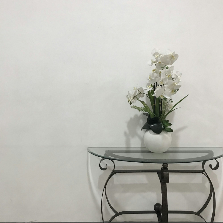 A glass table with a vase of flowers on top of it
