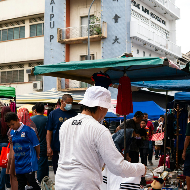 A group of people standing around a market