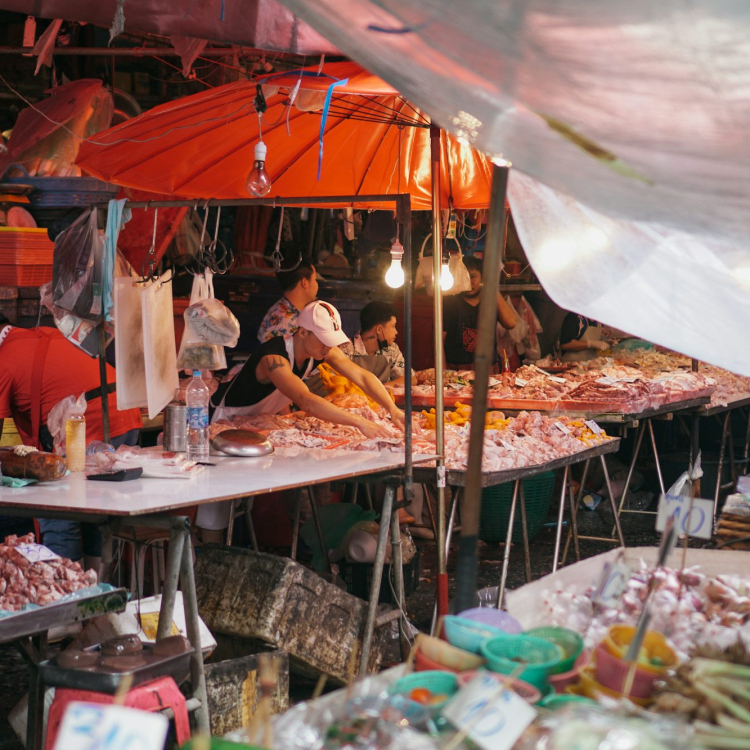 A group of people standing around a table filled with food