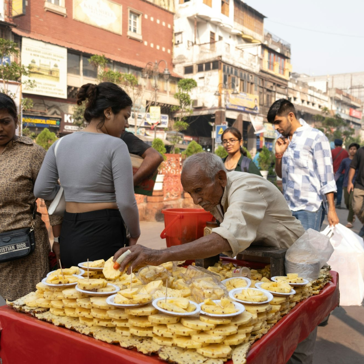 A group of people standing around a table with food on it