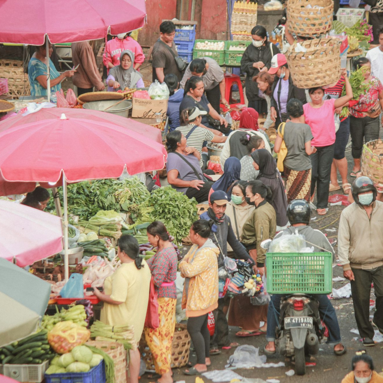 A large group of people walking around a market