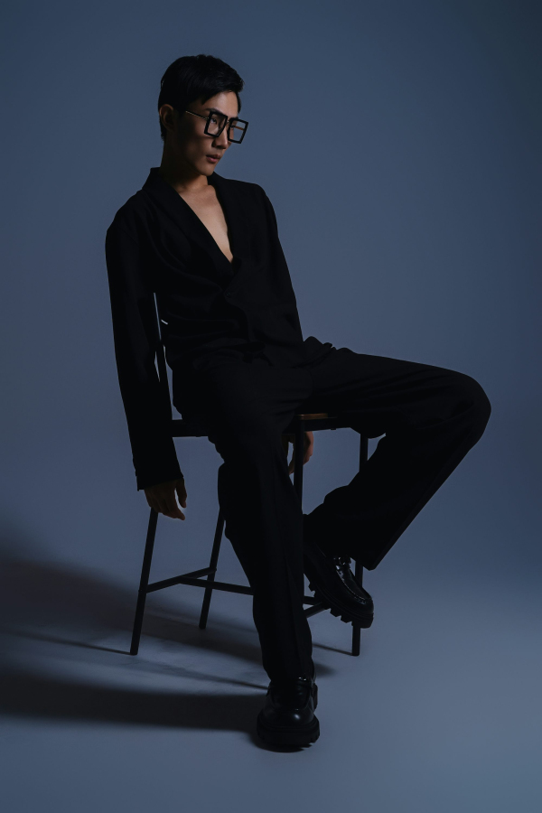 A man sitting in a chair with his legs crossed