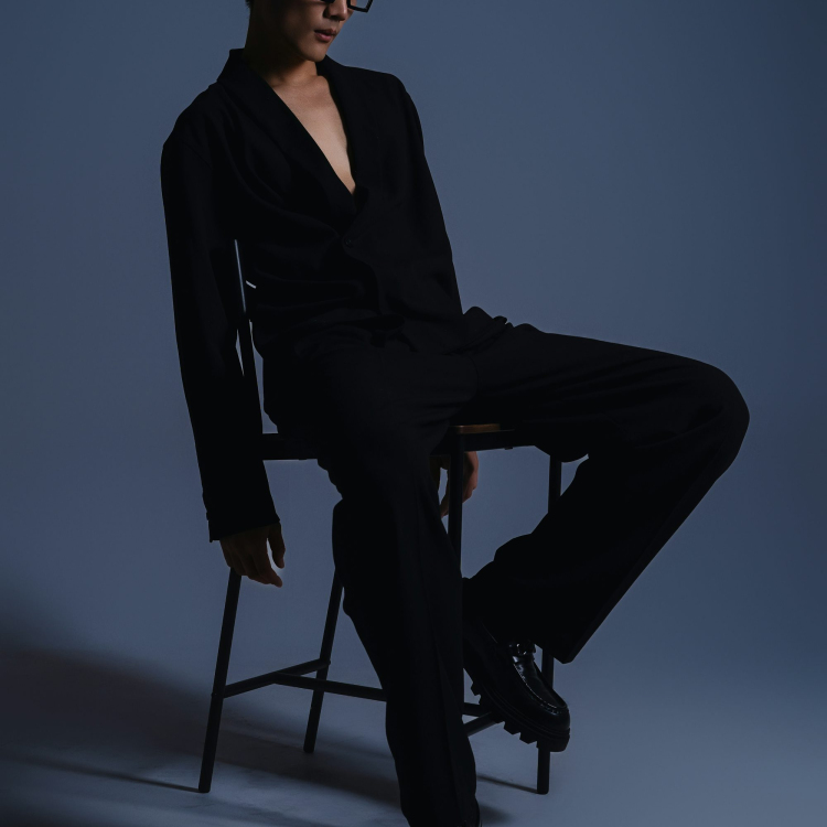 A man sitting in a chair with his legs crossed