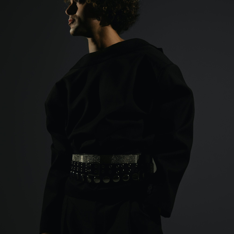 A man with curly hair wearing a black outfit