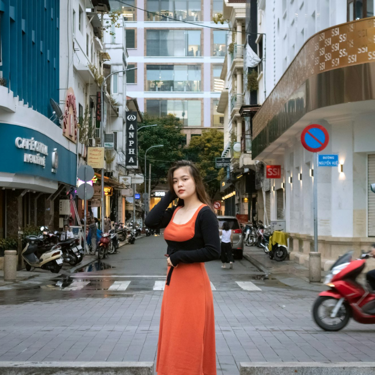 A person in a red dress standing in the middle of a street