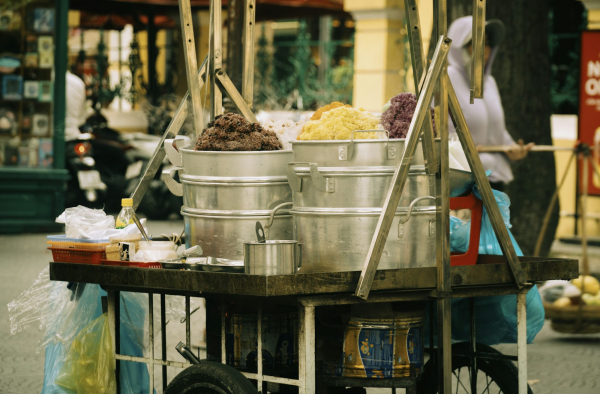 A person pushing a cart with food on it