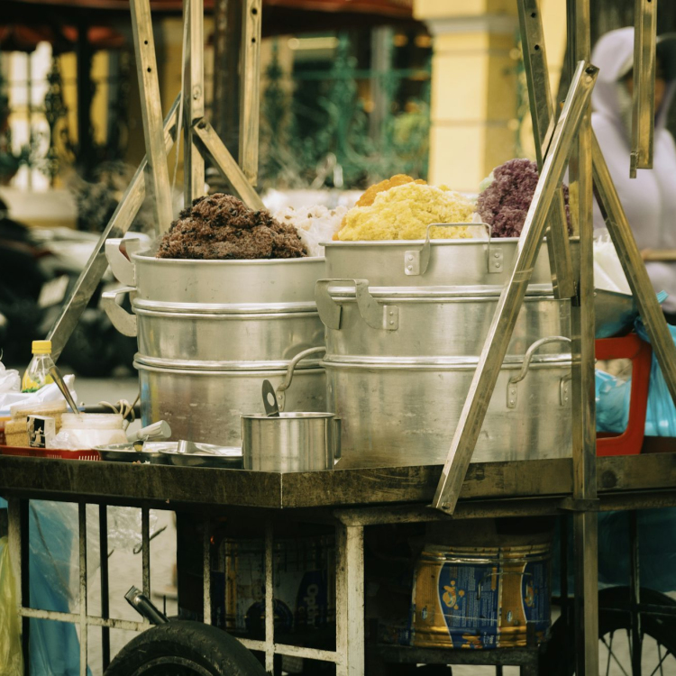 A person pushing a cart with food on it