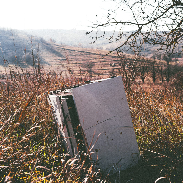A refrigerator sitting in the middle of a field