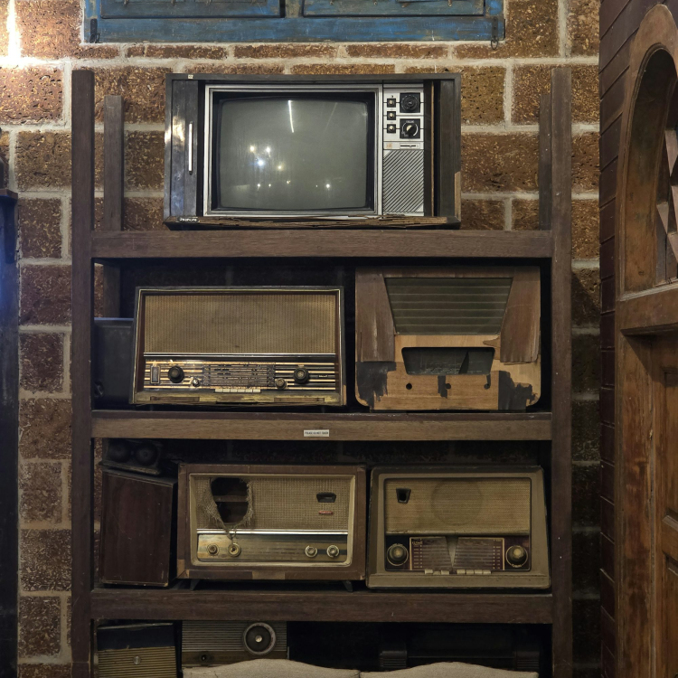 A room with a bunch of old tvs on a shelf