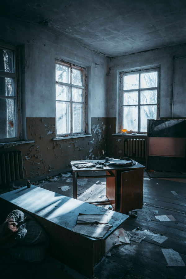 A room with a desk and two windows