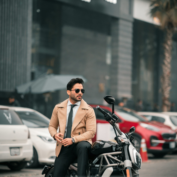 A stylish man sits on a motorcycle
