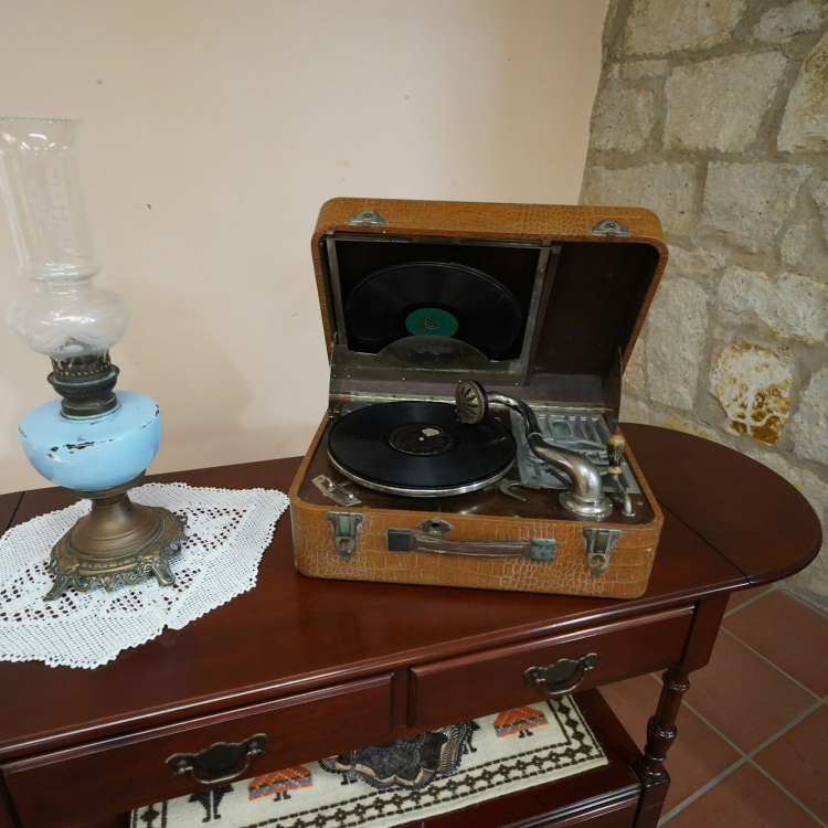 A table with a record player and a vase on it