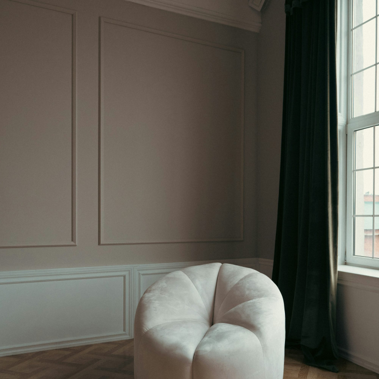 A white chair sitting in a room next to a window