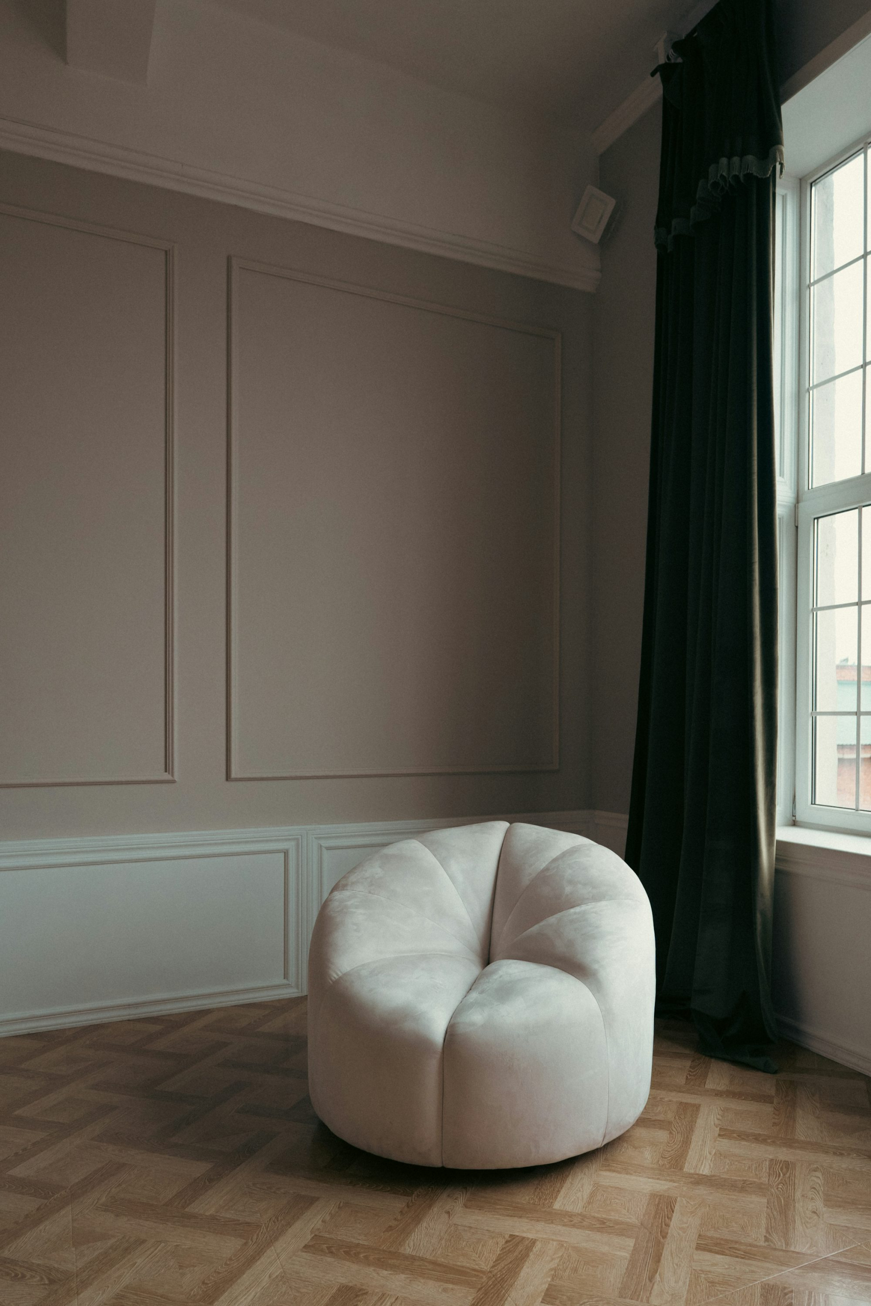 A white chair sitting in a room next to a window
