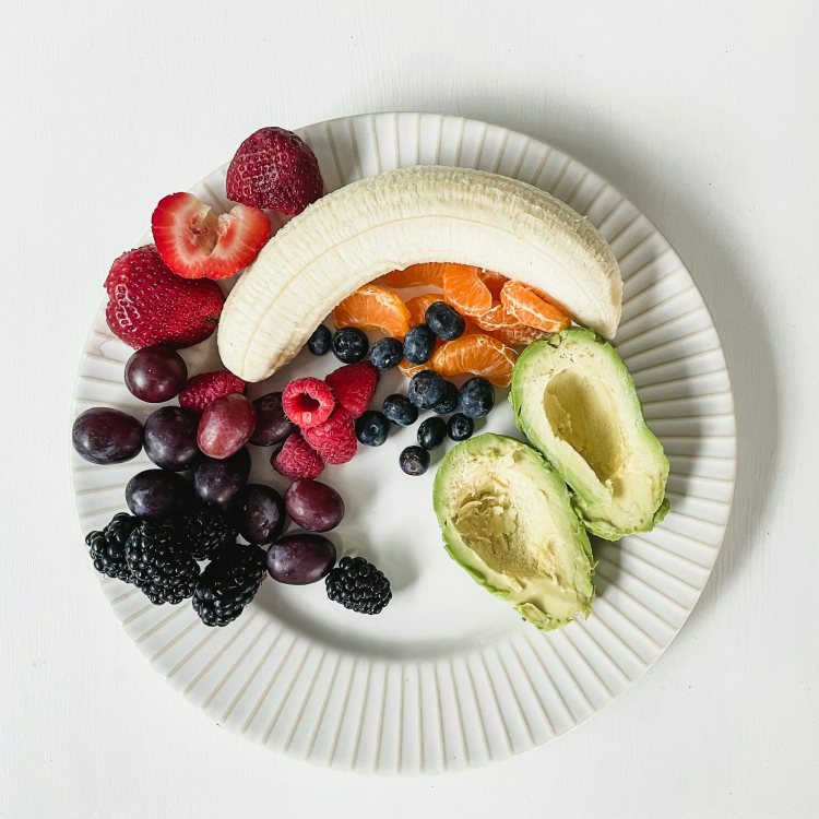 A white plate topped with fruit and a banana