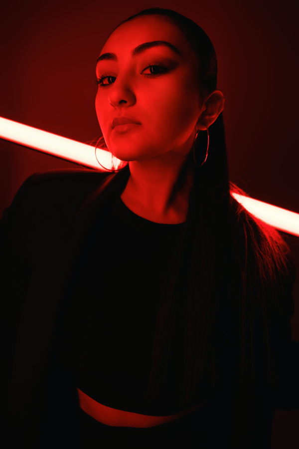 A woman poses dramatically in red lighting