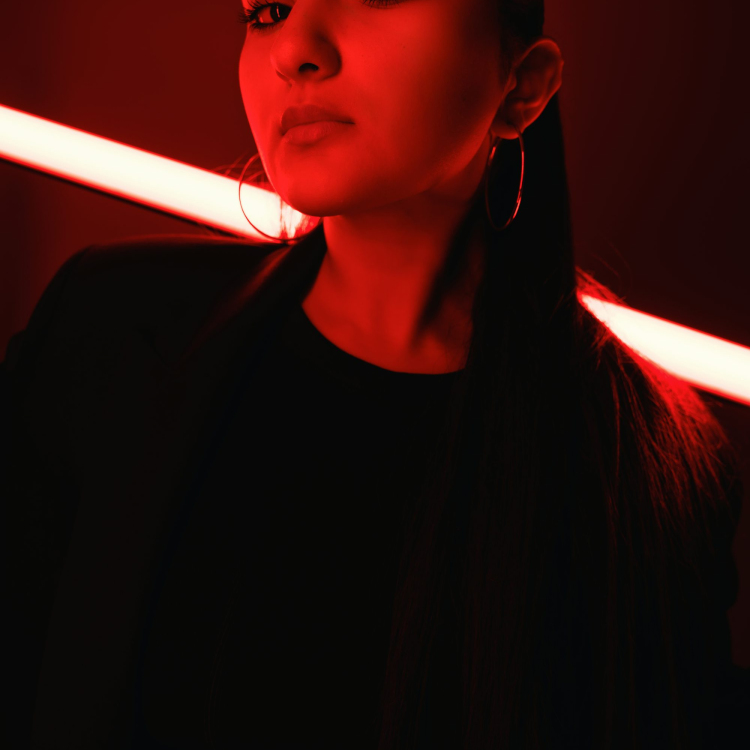 A woman poses dramatically in red lighting