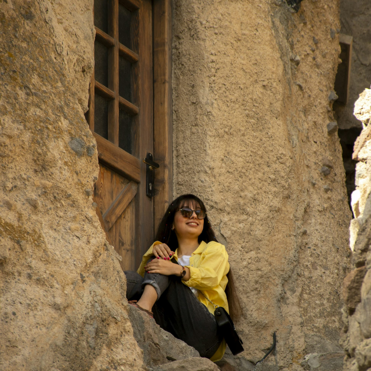 A woman sitting on a ledge in a stone building