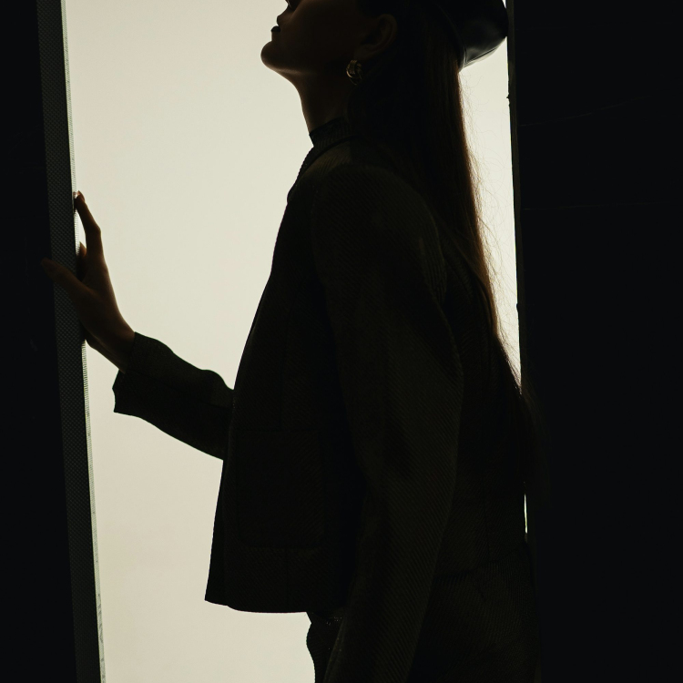 A woman standing in a doorway with a hat on her head