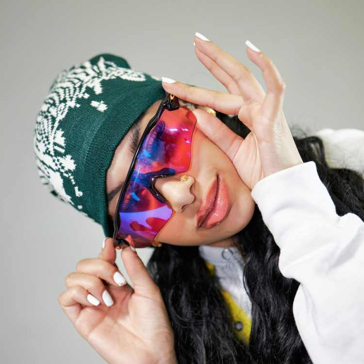 A woman wearing a green hat and a tie dye mask