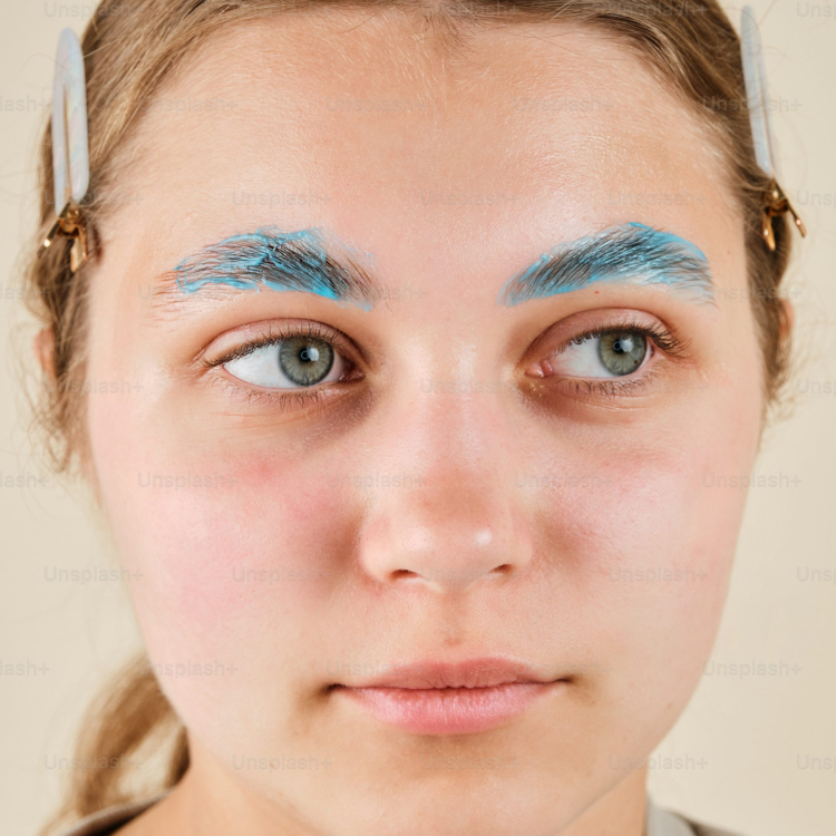 A woman with blue makeup and blue eyebrows