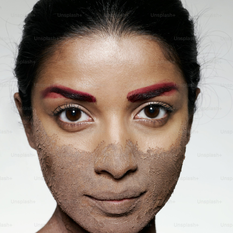 A womans face is covered in clay