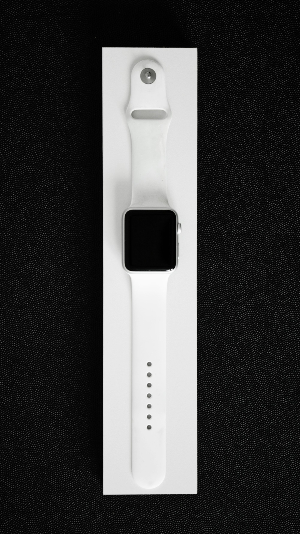 An apple watch in a white box on a black background
