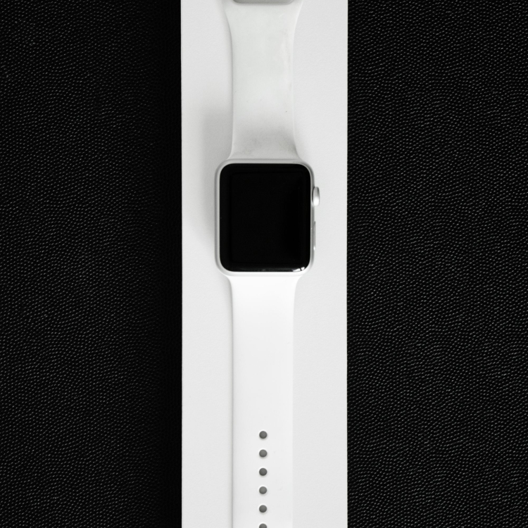 An apple watch in a white box on a black background