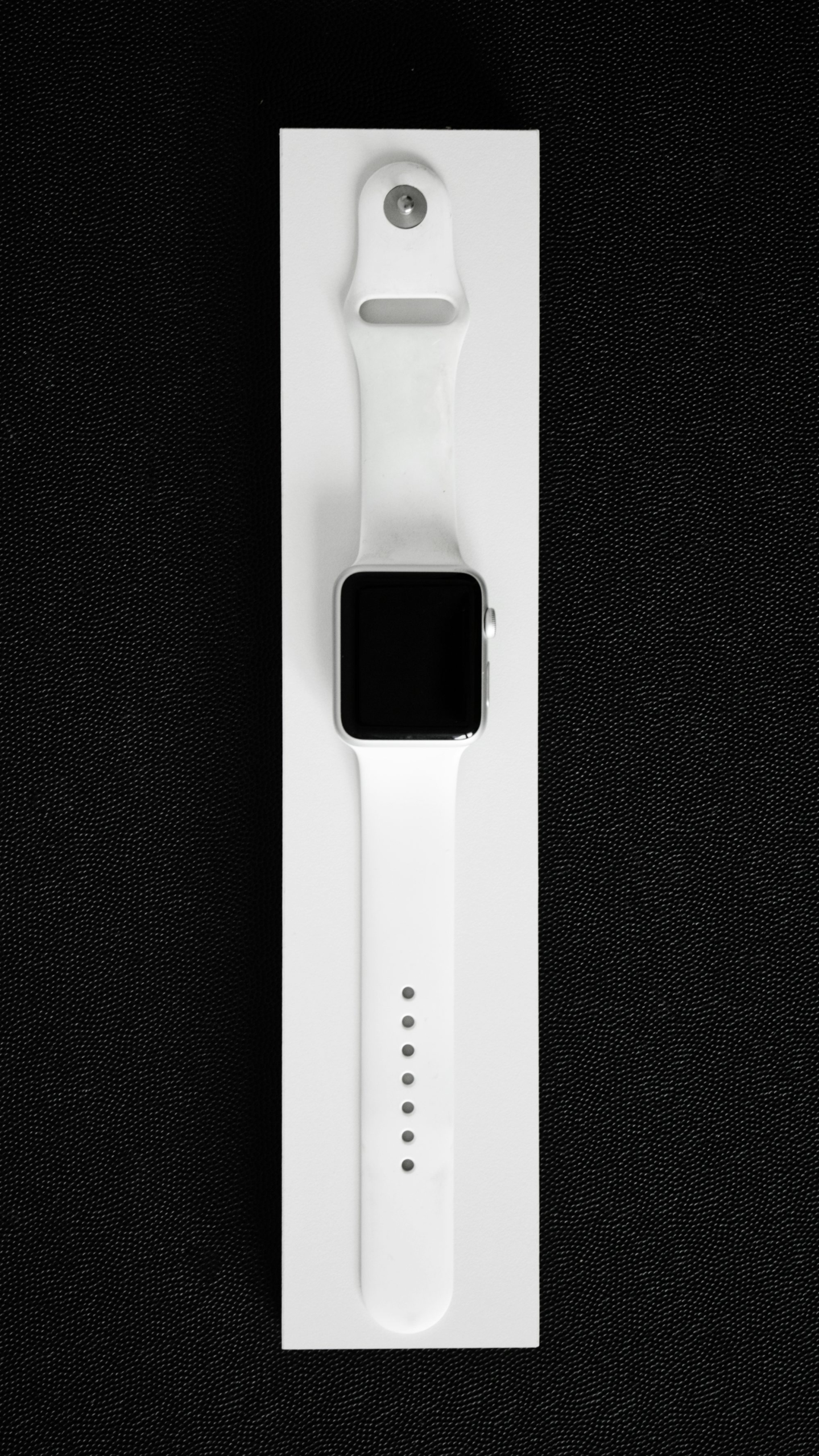 An apple watch in a white box on a black background