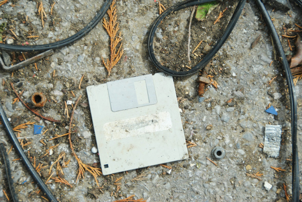 An old computer sitting on the ground surrounded by wires