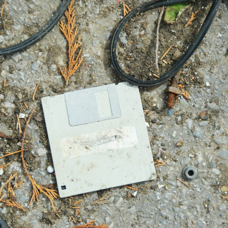 An old computer sitting on the ground surrounded by wires