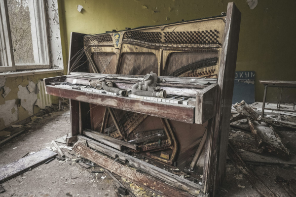 Brown wooden piano near yellow painted wall