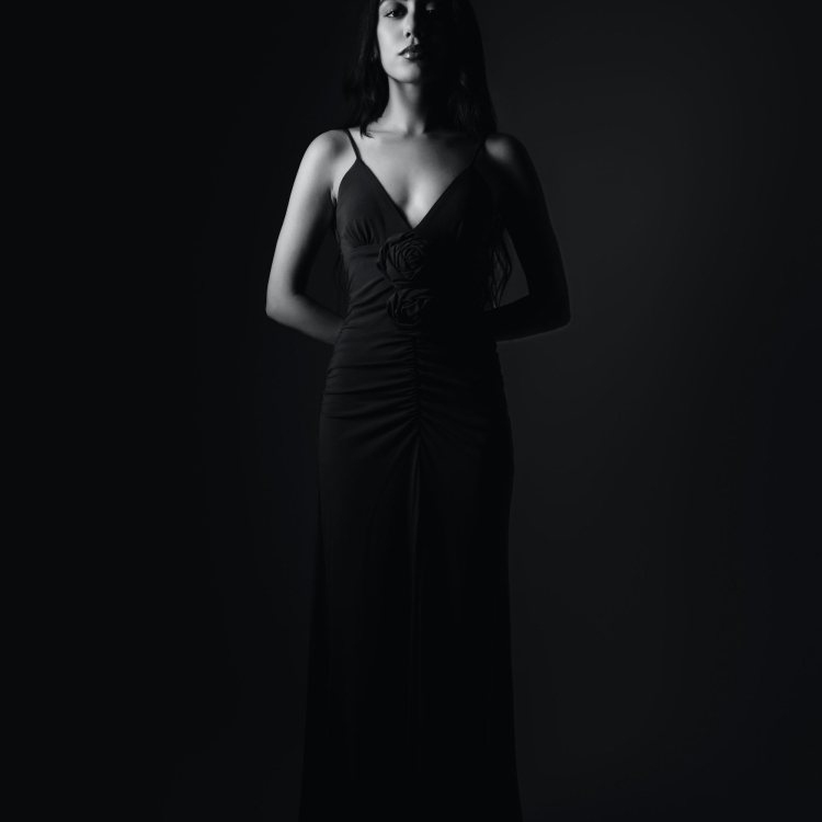 Elegant woman stands in a black dress