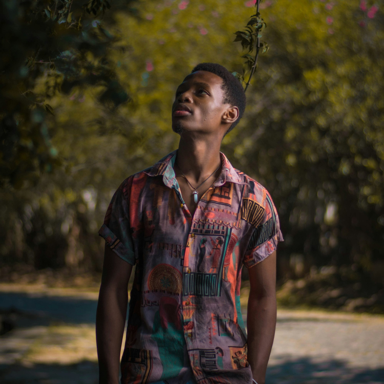 Man in red and blue button up shirt standing on road during daytime