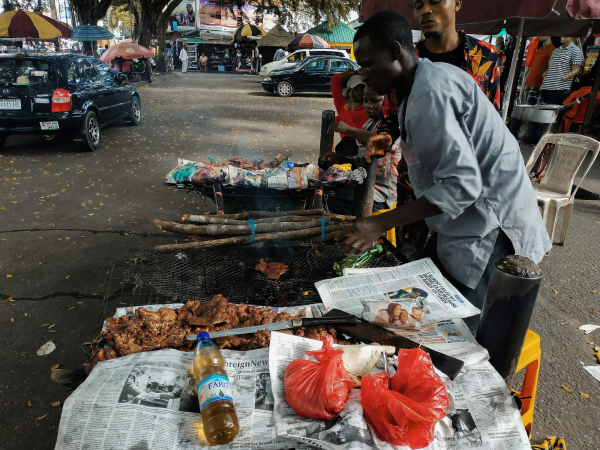 Man wearing gray dress shirt grilling meat