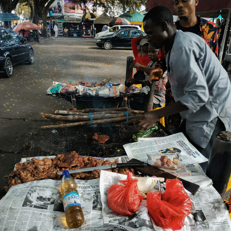 Man wearing gray dress shirt grilling meat