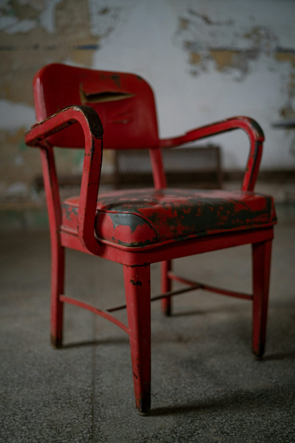 Red plastic armchair on gray concrete floor