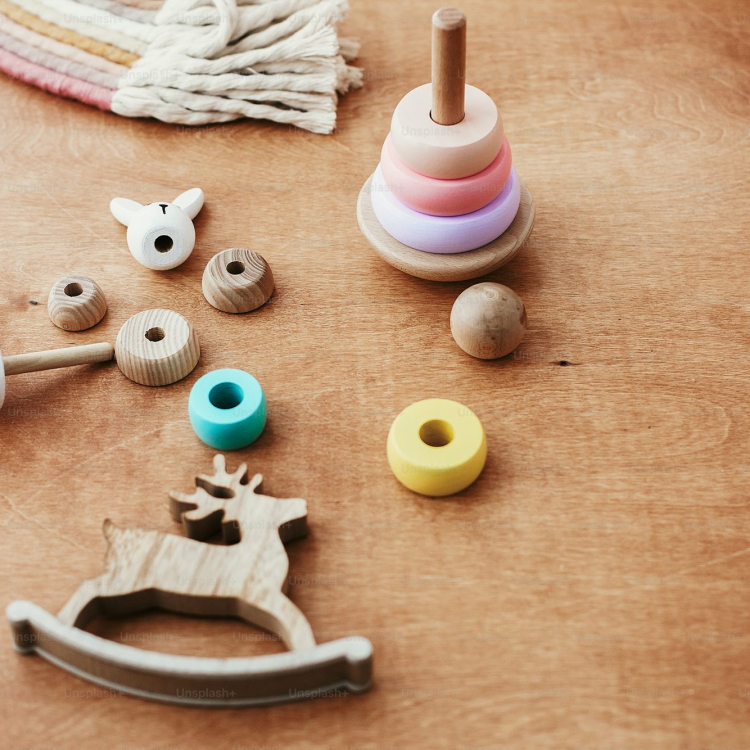 Stylish wooden toys for child on wooden table modern colorful wooden pyramid with disassemble rings