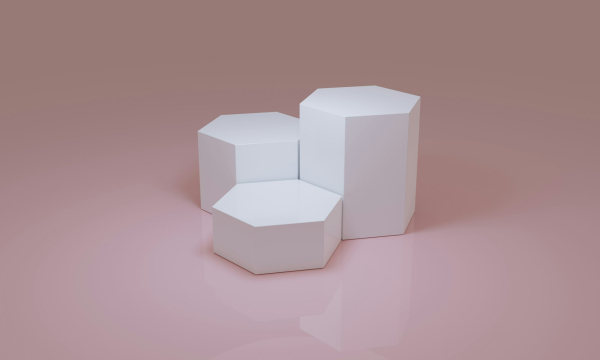 Three white boxes sitting on top of a pink surface