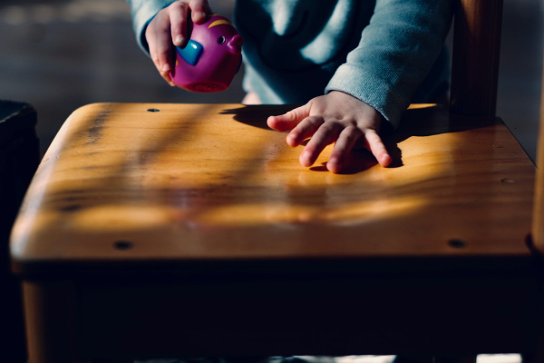 Toddler playing on table while holding purple ball