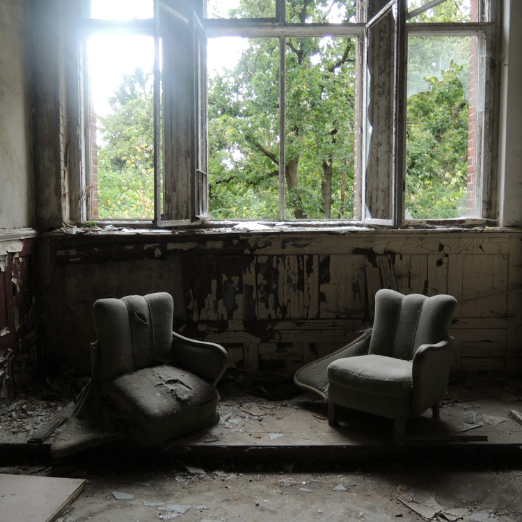 Two gray sofa chairs inside wrecked room